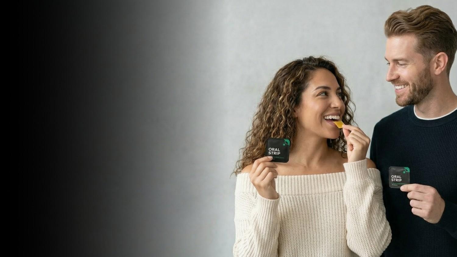 Man and woman eating snacks with a gray background
