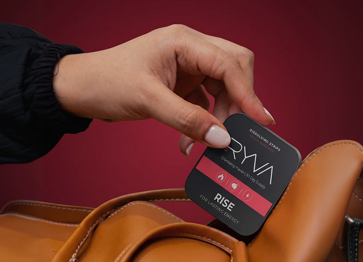 Hand holding a Ryva device against a red background